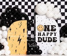 a black and white checkered wall with balloons in the shape of letters one happy dude