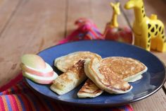 some pancakes and apples on a blue plate