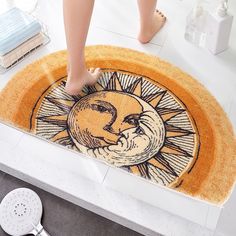 a person standing on top of a bath mat with the sun and moon in it