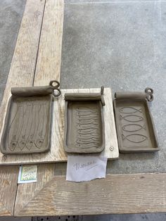 three cement trays sitting on top of a wooden table