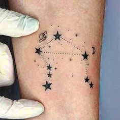 a person with a small star tattoo on their left arm and the stars are all around them