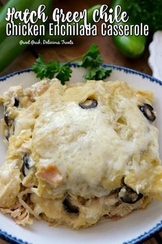 chicken enchilada casserole on a white and blue plate with parsley