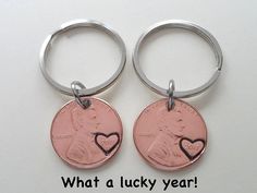 two penny key chains with the words what a lucky year written on one side and a heart in the other