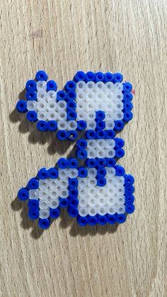 two pieces of blue and white beaded brooch sitting on top of a wooden table