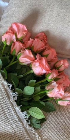 some pink flowers are laying on a pillow