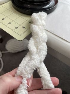 someone is holding a piece of white yarn