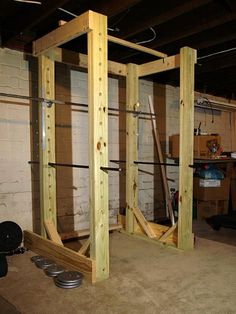 the inside of a garage with wooden beams and metal parts on the floor, in front of a white brick wall