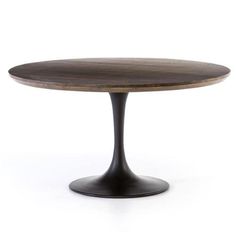 an oval wooden table sitting on top of a white floor next to a black metal base