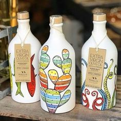 three bottles with different designs on them sitting on a table