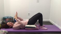 a woman is doing yoga on a mat with her hands in the air and one leg up