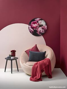 a living room with red walls and pink furniture in the corner, including a round chair