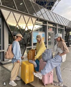 three people with suitcases waiting for their luggage at an airport terminal or boarding area