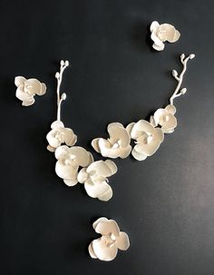 white flowers are arranged on a black surface