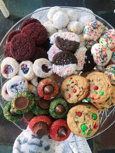 a platter filled with lots of different types of cookies and muffins