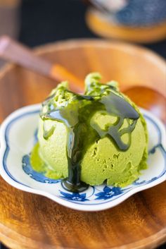 a scoop of green ice cream on a blue and white plate