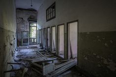 an abandoned building with broken windows and debris on the floor