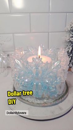 a candle that is sitting on top of a glass plate with snowflakes around it