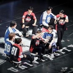 group of young men sitting on top of a basketball court