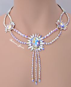 This necklace was created with Crystallized™ Swarovski Elements in aurora borealis clear crystals. This beautiful necklace is created with lots of different crystal shapes to capture the light and really sparkles! It has a small drop to full in the neckline but the large starburst design really captures the attention. The stones are not secured with any metal fittings so this will not snag your costume or your partners. This design will match any dress that you own because it has flesh tone back Luxury Party Necklaces For Festivals, Luxury Necklaces For Festivals, Luxury Festive Ceremonial Necklaces, Luxury Round Bead Crystal Necklace For Formal Occasions, Luxury Necklaces For Party And Festivals, Luxury Necklaces For Party Festivals, Luxury Hallmarked Jewelry For Opera, Luxury Festival Necklaces With Round Beads, Luxury Intricate Design Necklaces For Festivals