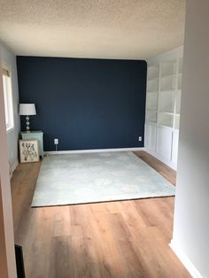 an empty living room with blue walls and wood floors