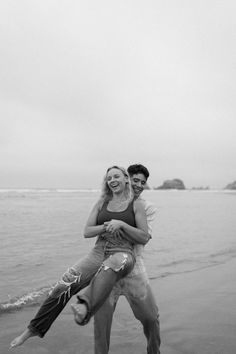 a man carrying a woman on his back at the beach