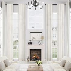 a living room filled with furniture and a fire place in front of a window covered in curtains