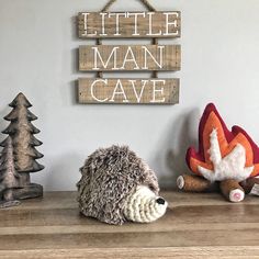 there is a stuffed hedge sitting on the shelf next to two little man cave signs