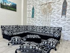 a black and white couch sitting on top of a hard wood floor next to a wall