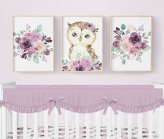 two framed pictures hang above a crib in a baby's room with purple flowers and an owl