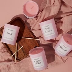 candles and matches on a pink blanket next to a wooden tray