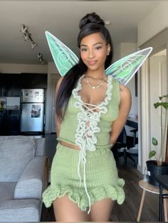 a woman wearing a green fairy costume standing in a living room