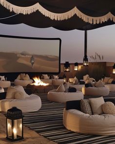 an outdoor seating area with fire pit and movie screen