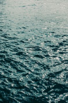 the water is very calm and blue in this photo, it looks like there are waves coming