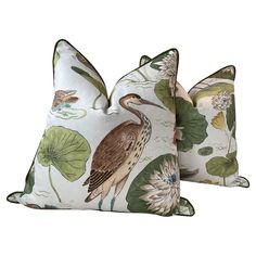 two decorative pillows with birds and water lilies on them