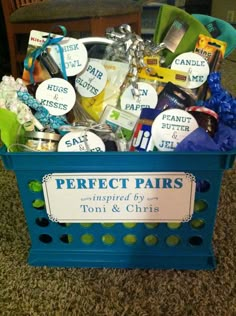 a blue basket filled with lots of different types of items on top of a carpet