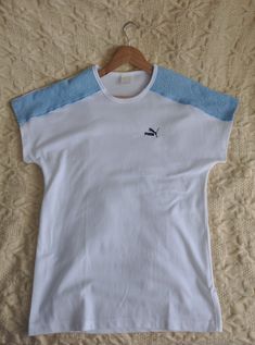 Vintage white and baby blue PUMA sports top, from the 1980s Summer 80s PUMA top with dolman short sleeves and long straight shape. The top features light blue terry cloth pieces on the shoulders, the rest is white! Has the brand's logo on the front Material - cotton and polyester, fabric is thick, not lightweight! Size - L Measurements (taken while top is lying flat, double armpit to armpit): Shoulders (undefined), measured from one sleeve's end to the other - 28.5 inches / 72.4 cm Armpit to Arm Cheap 90s Style Sports T-shirt, 1980s Summer, Summer 80s, Cloth Pieces, 80s Sports, 80s Summer, Hipster Jeans, White Peasant Blouse, Puma Sport