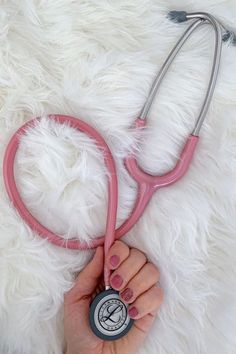 a person holding a stethoscope on top of a fluffy white blanket with their hand