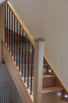 a wooden stair case with metal handrails and lights on the treading area