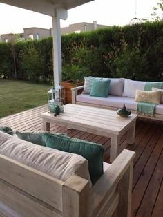 a wooden deck with couches and tables on it