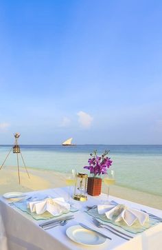 the table is set for two on the beach