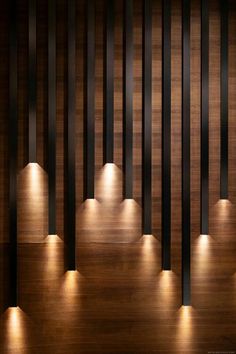 some lights that are on the side of a wooden wall with black bars and an arrow