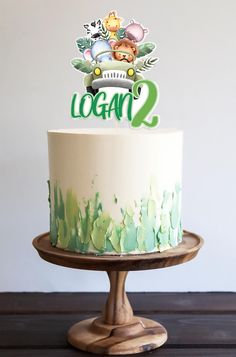 a white and green cake sitting on top of a wooden table next to a sign that says vegan 2