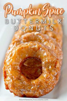 pumpkin spice buttermilk donuts on a white plate with the words, pumpkin spice buttermilk donuts