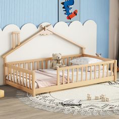 a wooden crib with a teddy bear sitting in it next to a blue wall