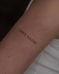 a woman's arm with the word love you written in cursive font