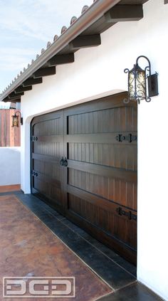 a garage door is open on the side of a house in front of a white wall