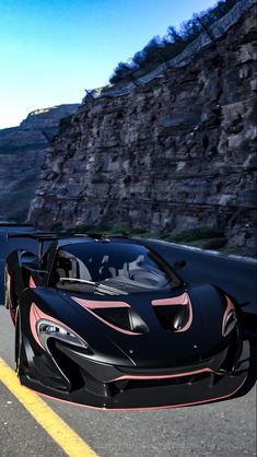 a black and pink sports car driving down a road next to a rocky mountain side