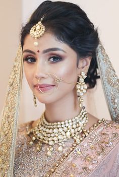 a woman in a bridal outfit with jewelry on her neck and headpieces