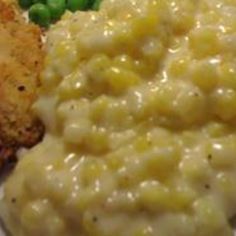 a white plate topped with mashed potatoes and green peas