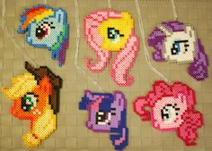 some little pony beaded necklaces hanging on a wall